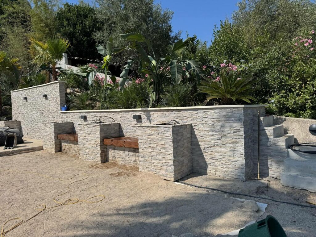 Nos réalisations Pose du parement pierre sur un mur de soutènement en cours de chantier — PACA RINOH SERVICES