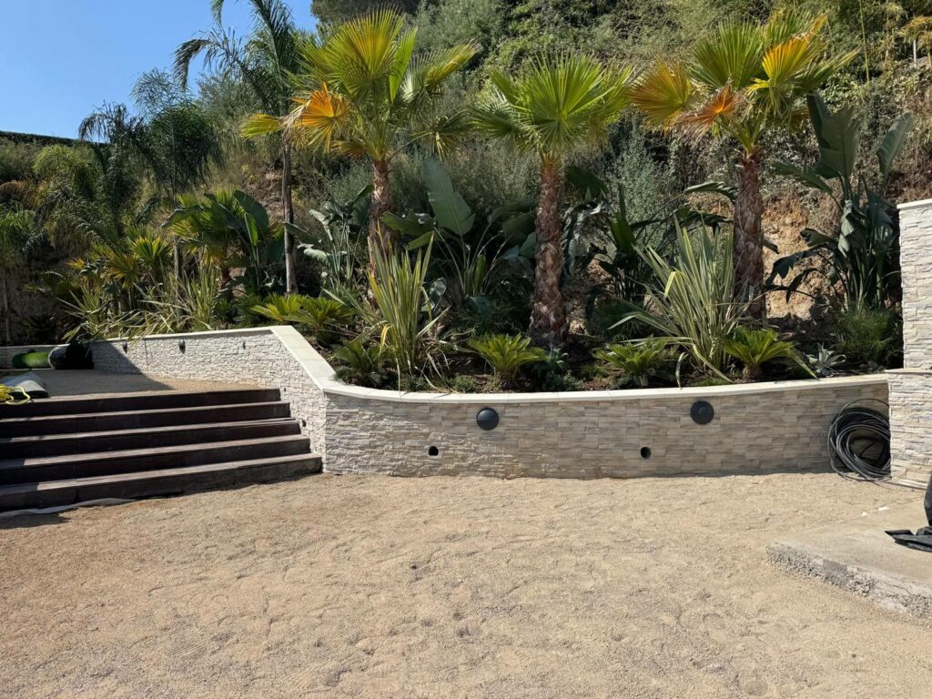 Nos réalisations Mur de soutènement habillé en parement pierre et escalier d'accès au jardin, réalisés par PACA RINOH SERVICES