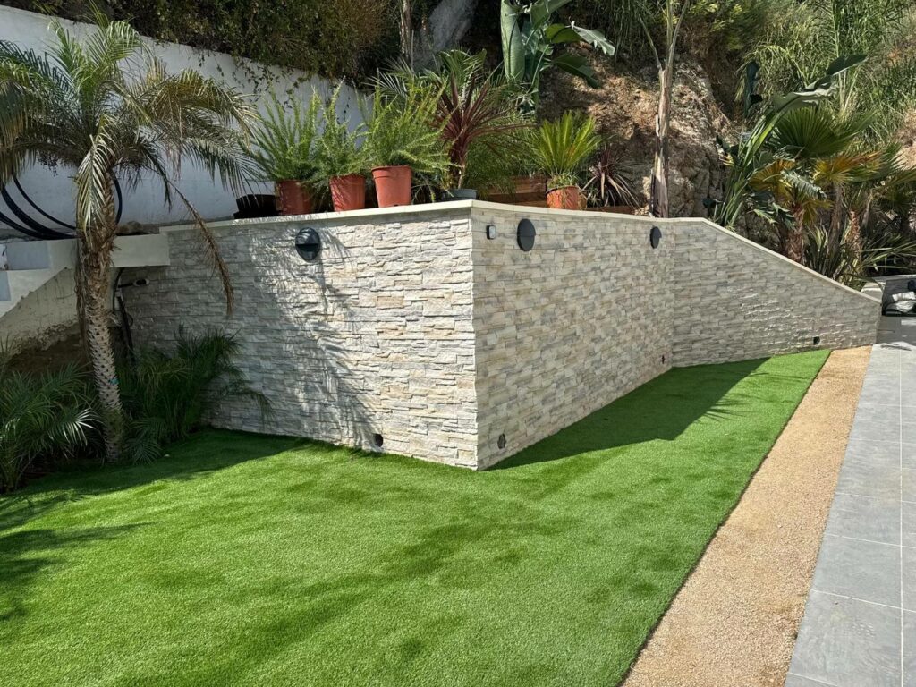 Nos réalisations Terrasse engazonnée gagnée sur un talus, mur de soutènement parementé en pierre — PACA RINOH SERVICES